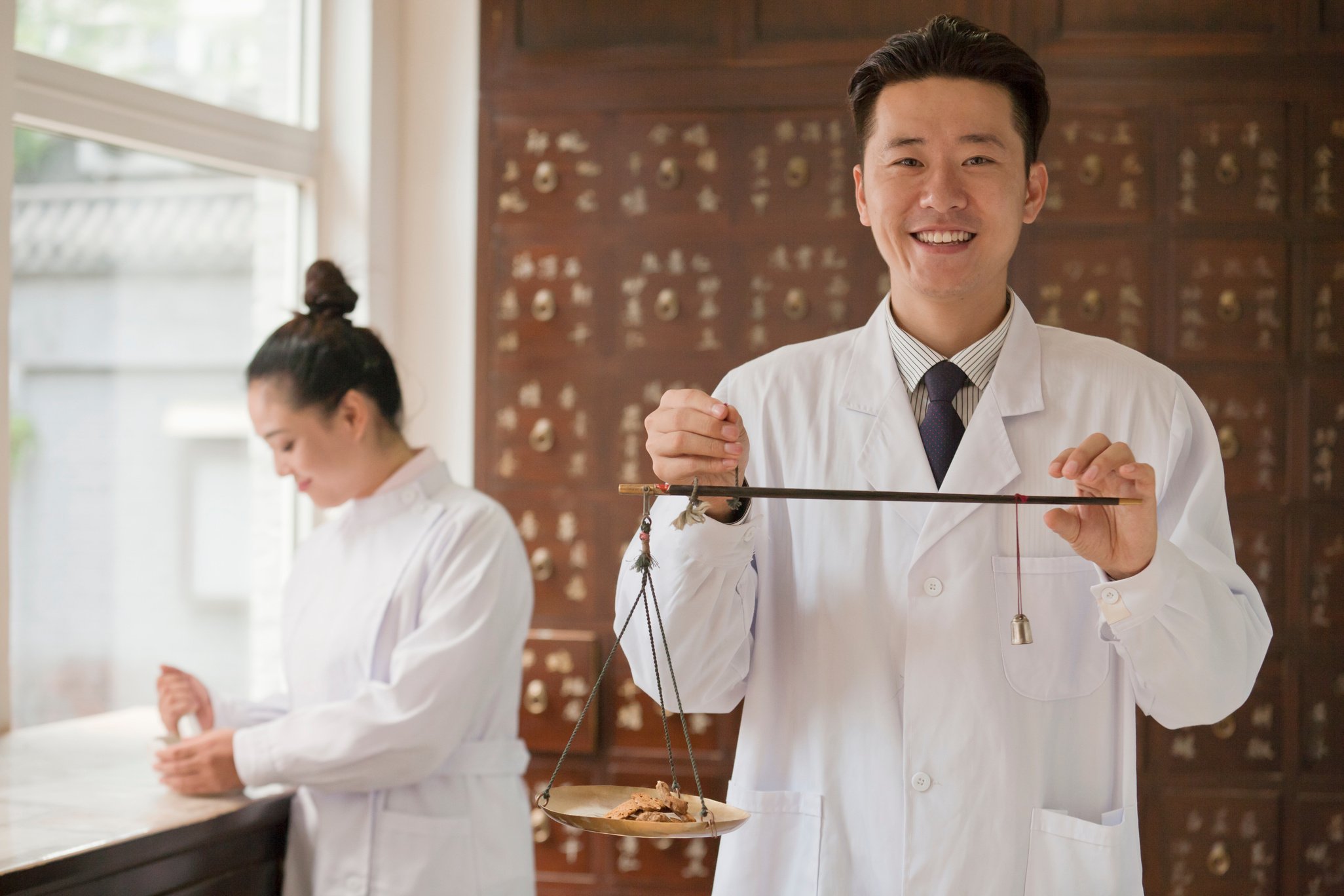 Traditional Chinese medicine doctor using scale